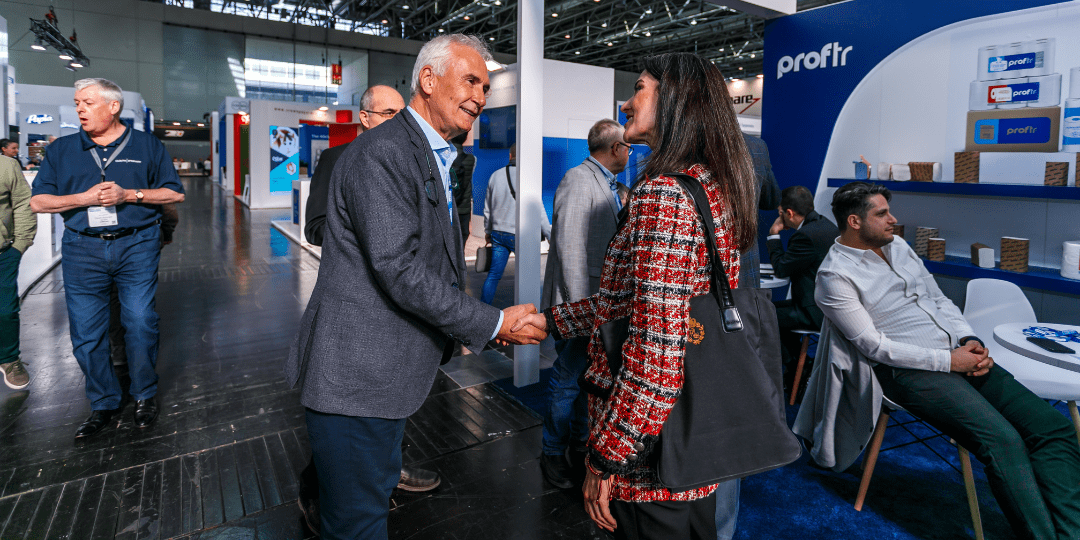 Tissue World Exhibitor shaking hands with visitor